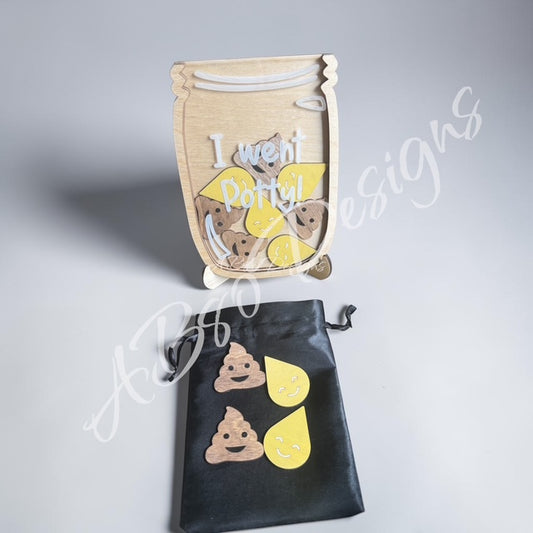 Mason jar-shaped product with 'I went potty!' text and poop emoji designs, displayed with a black drawstring bag on a gray background.
